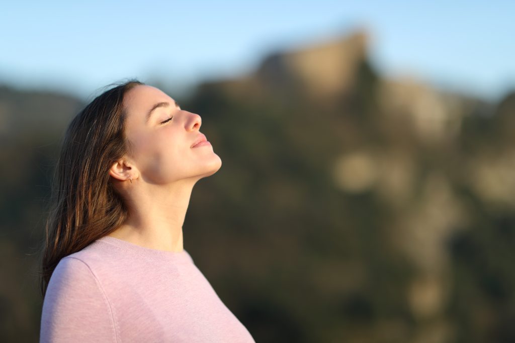 A relaxed woman outside in the mountains.
