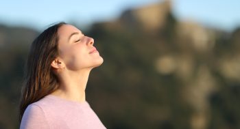 A relaxed woman outside in the mountains.