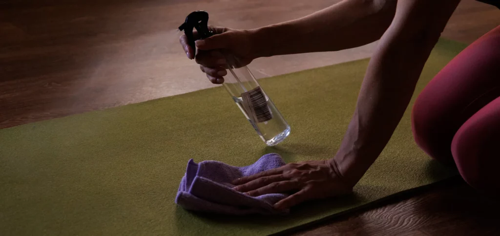 A woman cleaning her yoga mat.
