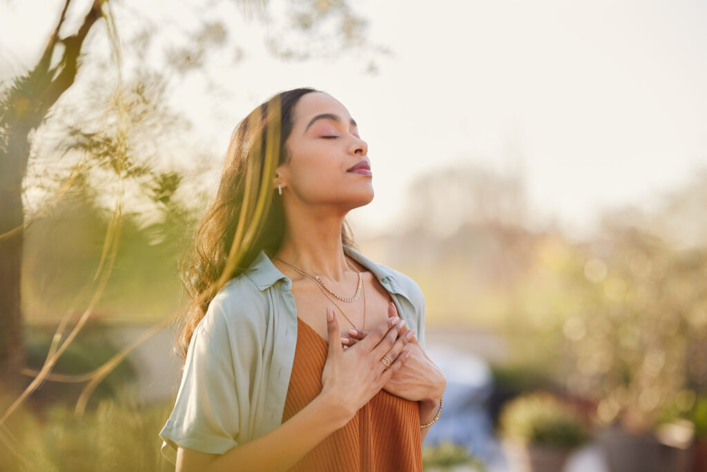 A woman breathing outside at sunset.