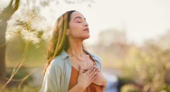 A woman breathing outside at sunset.